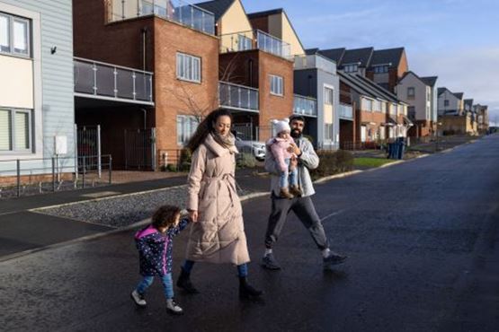 Family walking in front of flats