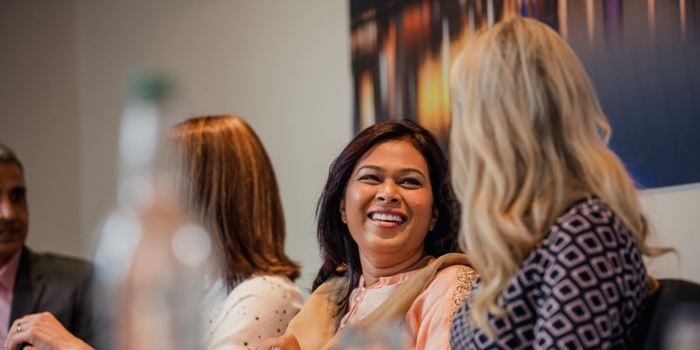 Smiling people in a meeting room with bottles of water on the table