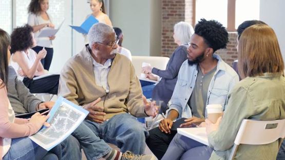 Several people discuss something in a small  group