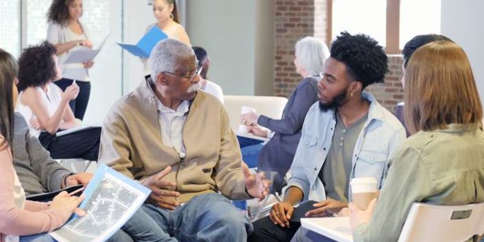 Several people discuss something in a small  group