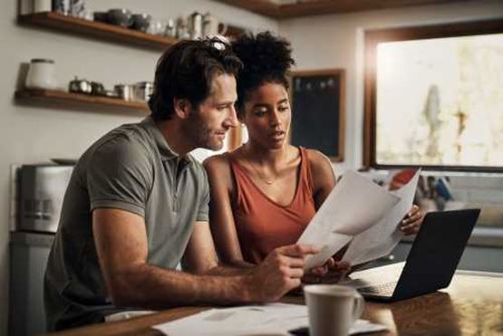 Couple sorting paperwork at table