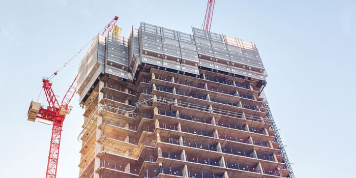 A block of flats under construction with a crane next to it