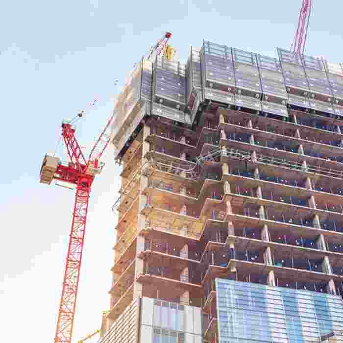 A block of flats under construction with a crane next to it