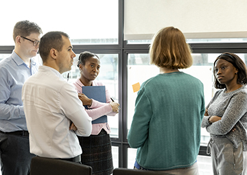 Colleagues talking near a window