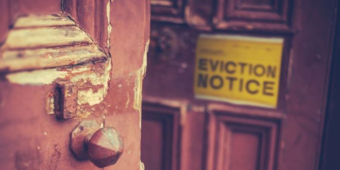 Yellow eviction notice on wooden front door