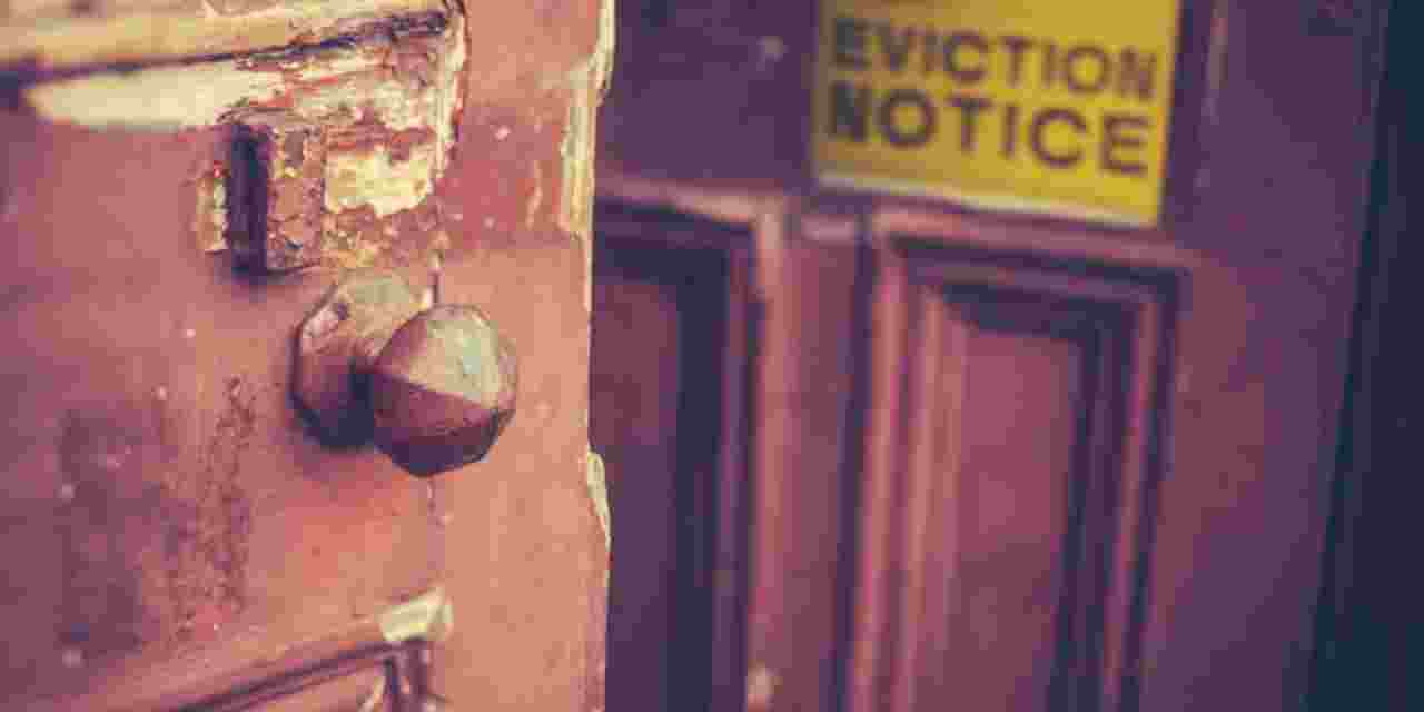 Yellow eviction notice on wooden front door