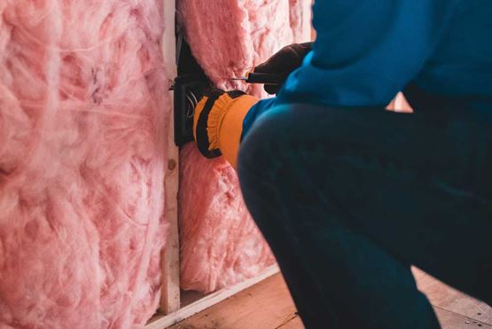 Worker installing wall insulation