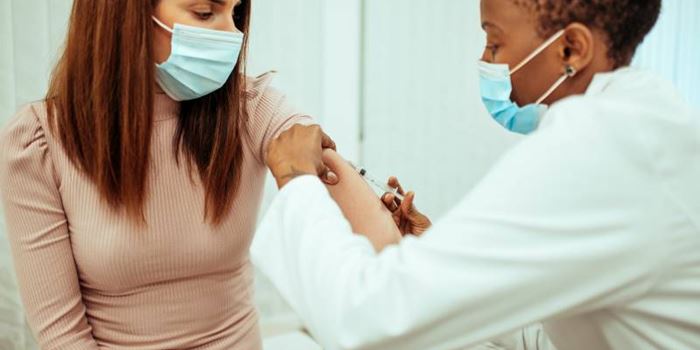 A doctor administers the COVID-19 vaccine to a woma