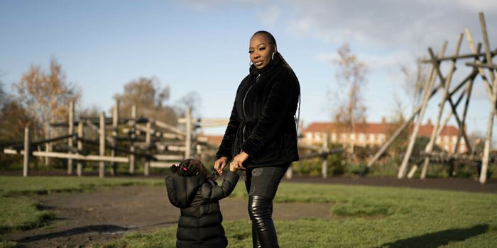 A mother and a child holding hands in the park