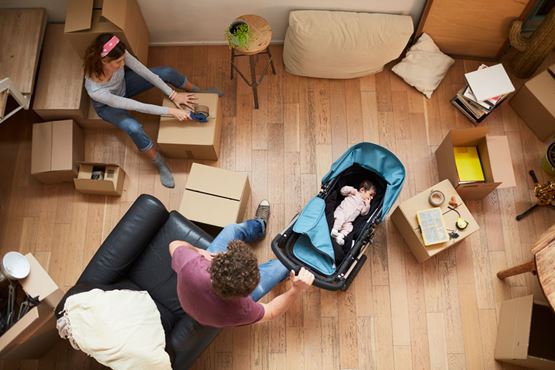 Arial view of a couple with a baby surrounding by packing boxes