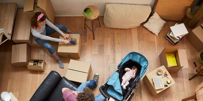 Arial view of a couple with a baby surrounding by packing boxes