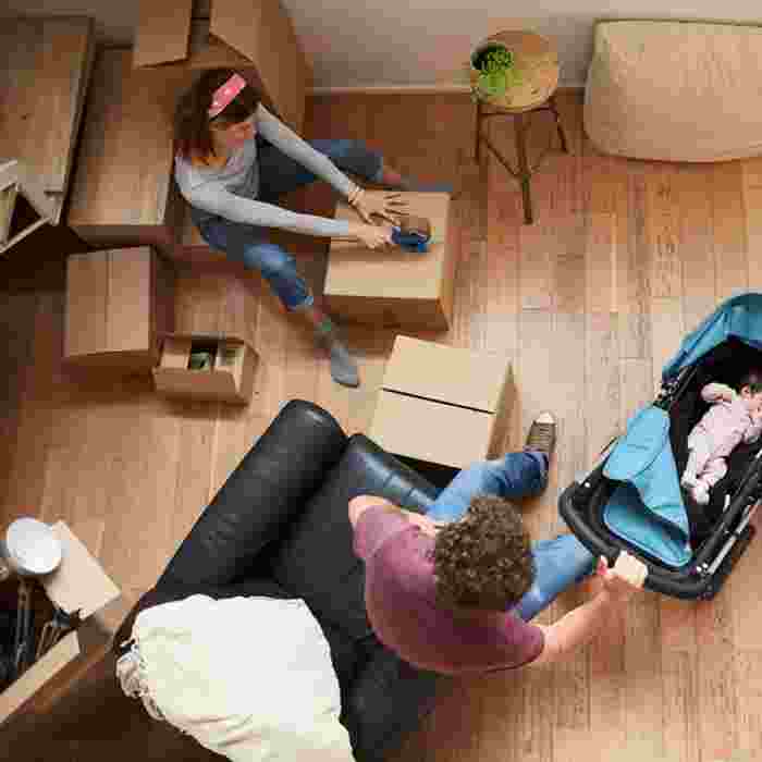 Arial view of a couple with a baby surrounding by packing boxes