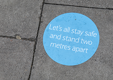 Sticker on floor reminding people to stand two metres apart