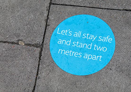 Sticker on floor reminding people to stand two metres apart