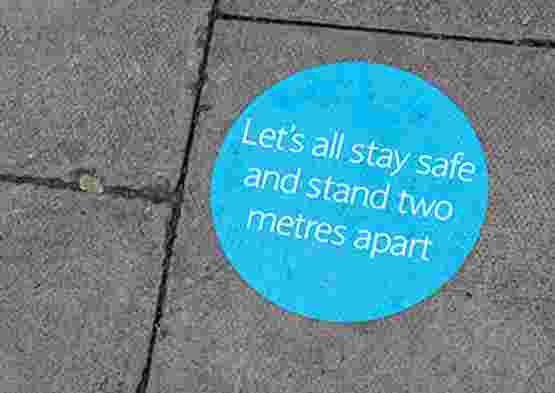 Sticker on floor reminding people to stand two metres apart