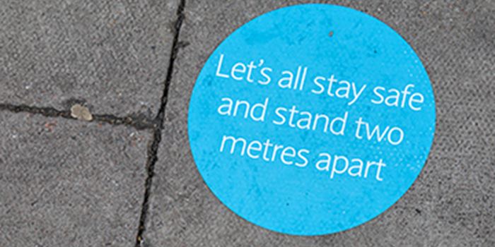 Sticker on floor reminding people to stand two metres apart