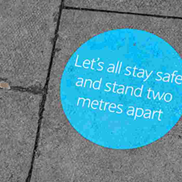 Sticker on floor reminding people to stand two metres apart