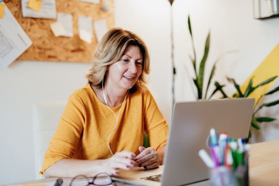 Woman in yellow top working on her laptop