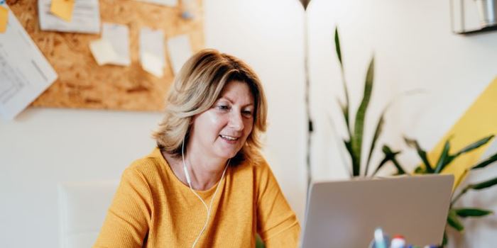 Woman in yellow top working on her laptop