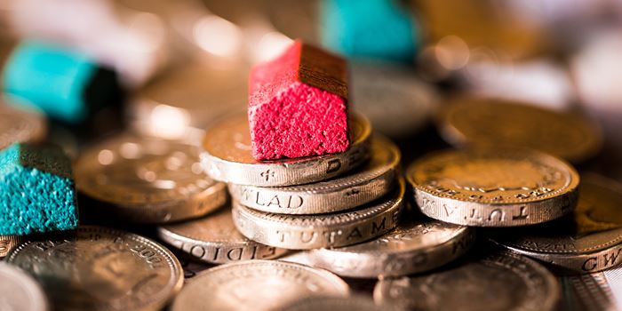 stack of money with wooden house