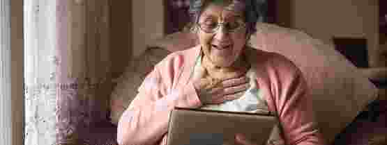 Woman sat in chair using tablet device
